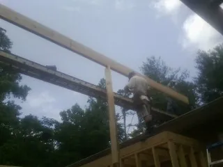 Carpenter setting a ridge beam over a new addition frame — Ice Dam Removal by Roofing Brothers in Warm Springs